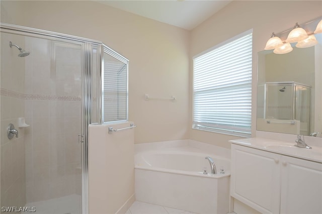 bathroom featuring plus walk in shower, vanity, and tile patterned flooring