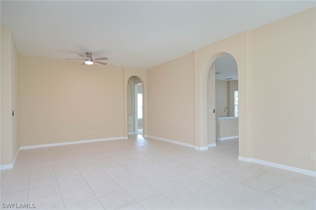 tiled spare room featuring sink and ceiling fan