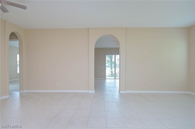 tiled empty room featuring ceiling fan