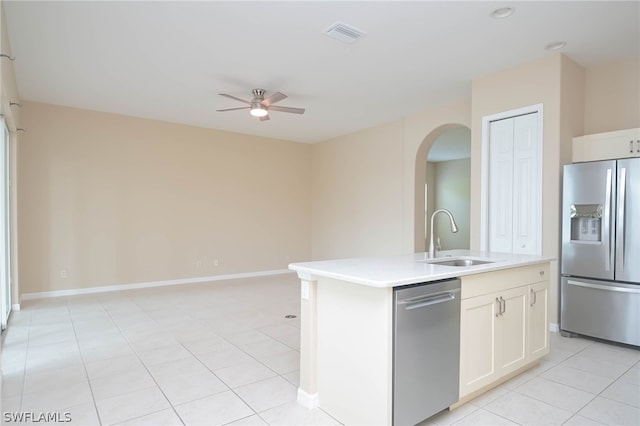 kitchen with white cabinetry, sink, appliances with stainless steel finishes, light tile patterned floors, and a kitchen island with sink