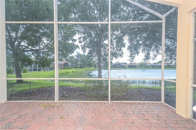 unfurnished sunroom featuring a water view