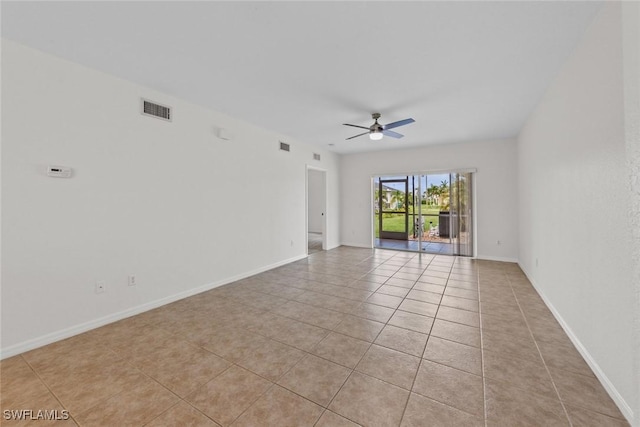 empty room with ceiling fan and light tile patterned floors