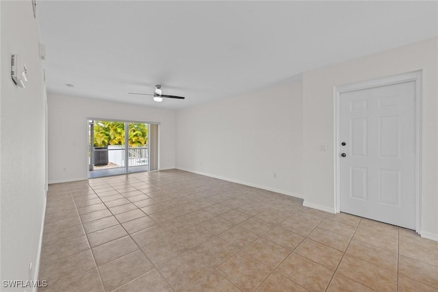 tiled spare room featuring ceiling fan