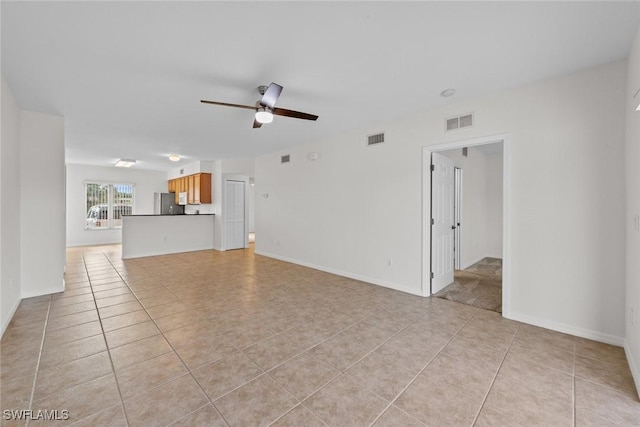 unfurnished living room featuring light tile patterned floors, baseboards, visible vents, and a ceiling fan