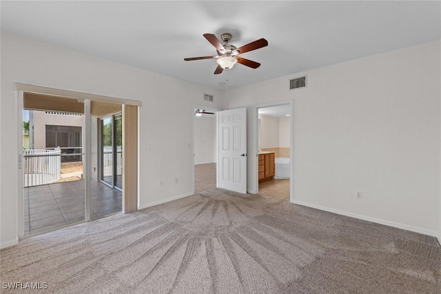 unfurnished bedroom featuring ensuite bathroom, access to outside, light carpet, and ceiling fan