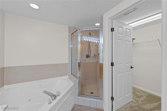 full bath featuring a shower stall, a spacious closet, visible vents, and a bath