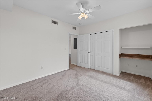 unfurnished bedroom with light colored carpet, visible vents, and electric panel