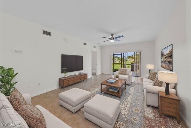 living room featuring ceiling fan, light tile patterned floors, visible vents, and baseboards