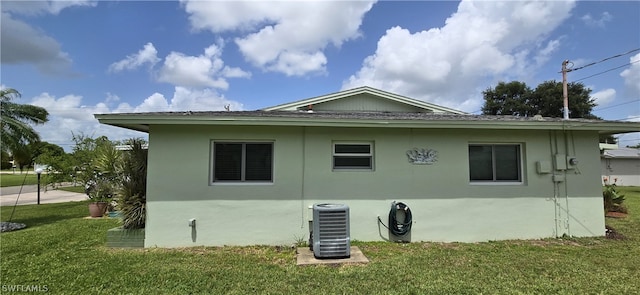 view of side of home with cooling unit and a lawn