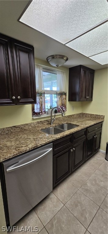 kitchen with light tile patterned flooring, dishwasher, sink, and stone countertops