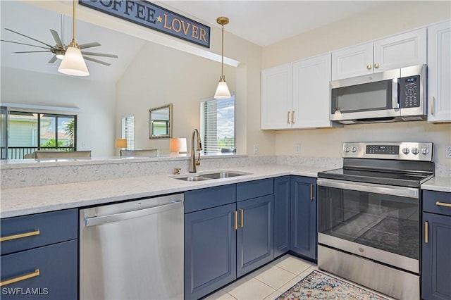 kitchen featuring decorative light fixtures, light tile patterned floors, appliances with stainless steel finishes, white cabinetry, and a sink