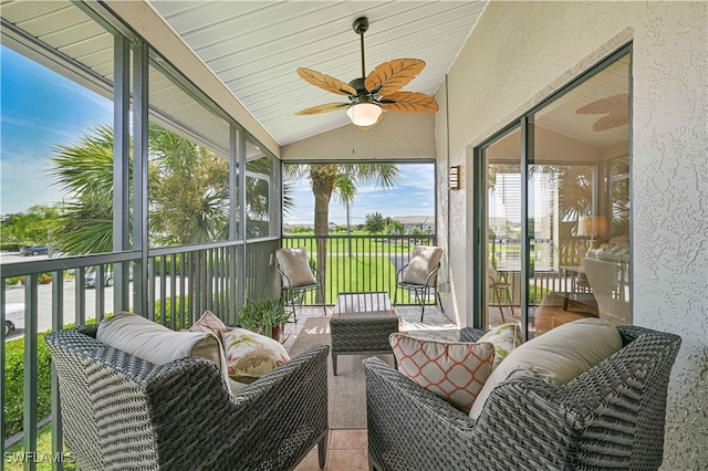 sunroom featuring ceiling fan and vaulted ceiling