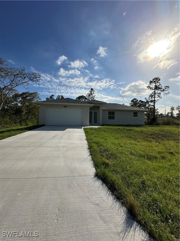 ranch-style house featuring a garage and a front lawn