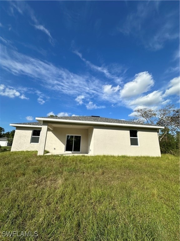 rear view of property featuring a yard