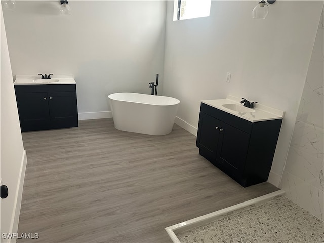 bathroom with a tub, vanity, and hardwood / wood-style flooring