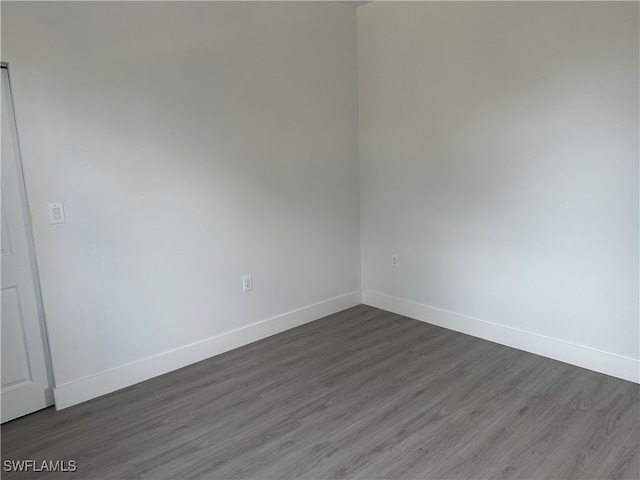 empty room with dark hardwood / wood-style flooring