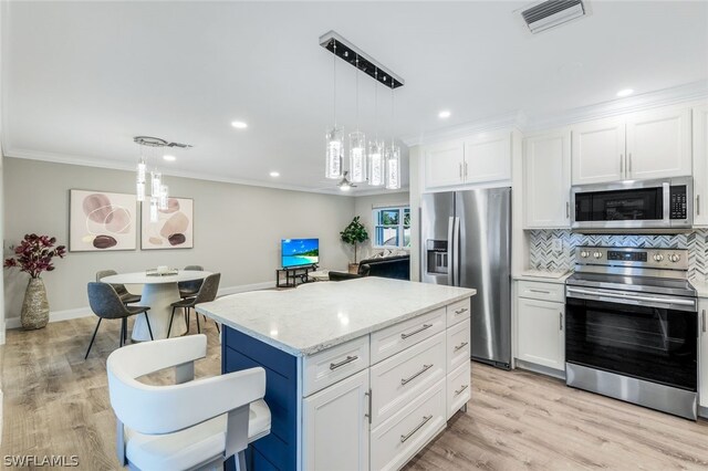 kitchen with white cabinets, decorative backsplash, light wood-type flooring, light stone counters, and appliances with stainless steel finishes