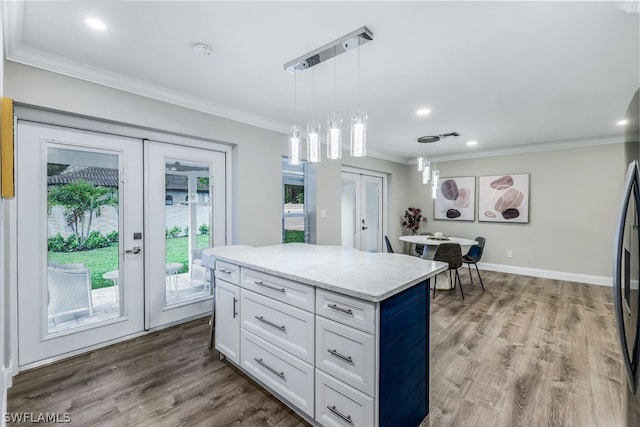 kitchen with french doors, white cabinets, a center island, hardwood / wood-style floors, and decorative light fixtures