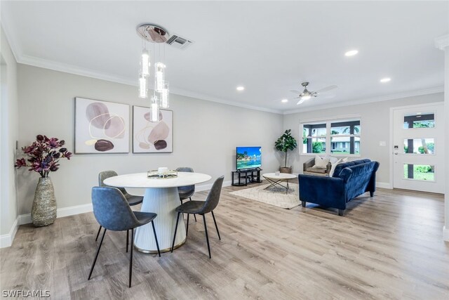 dining space featuring crown molding, light hardwood / wood-style flooring, and ceiling fan