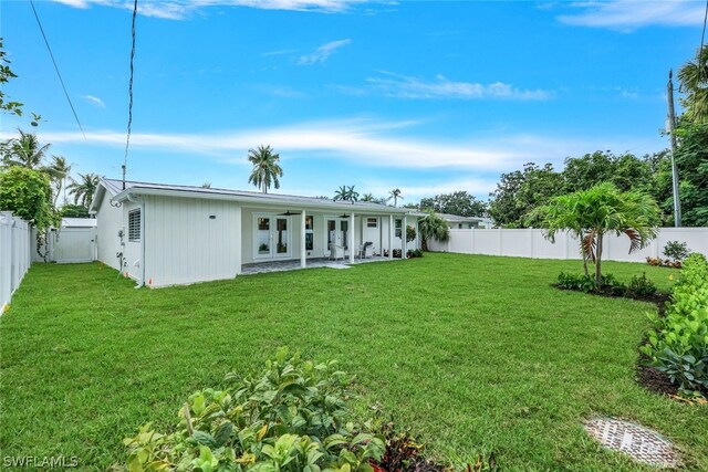 rear view of property featuring a patio, french doors, and a yard