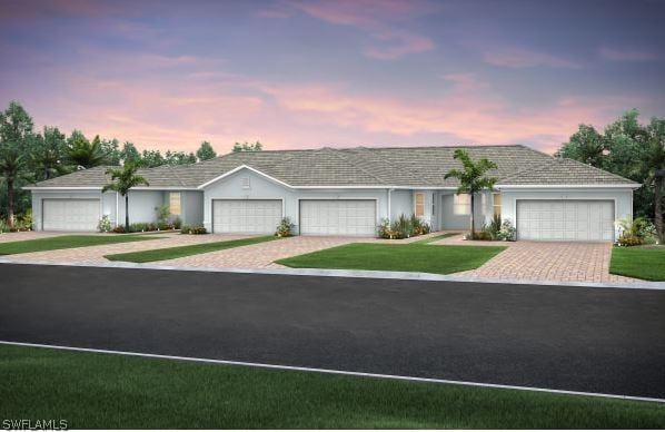 ranch-style home featuring a garage and a yard