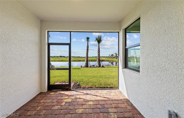 unfurnished sunroom with a water view and a healthy amount of sunlight