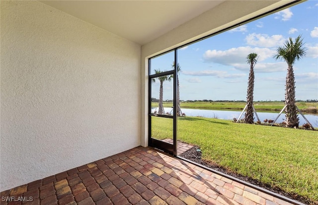 unfurnished sunroom featuring a water view