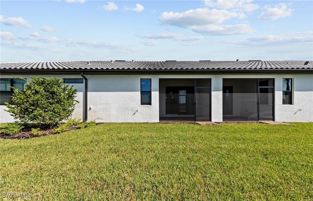 rear view of property featuring a sunroom and a yard