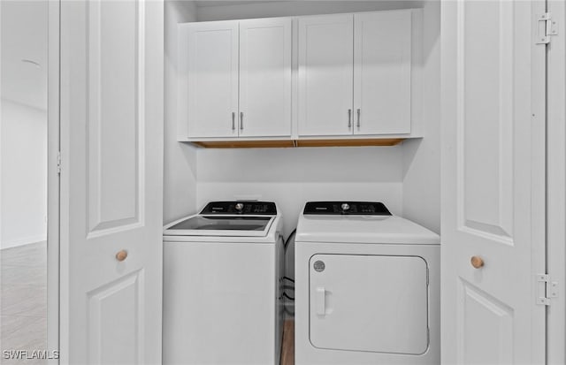 laundry room featuring cabinets and washer and dryer