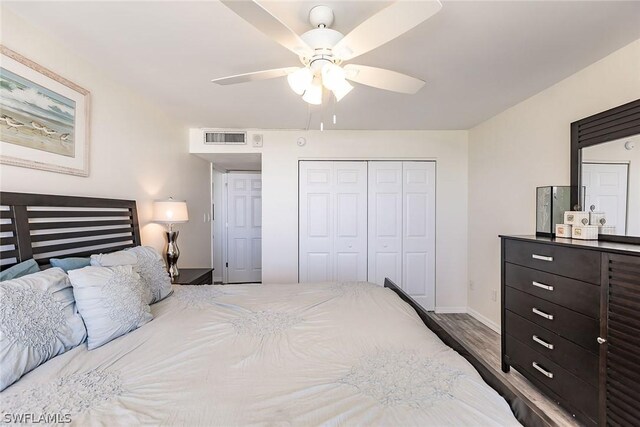 bedroom with a closet, wood-type flooring, and ceiling fan