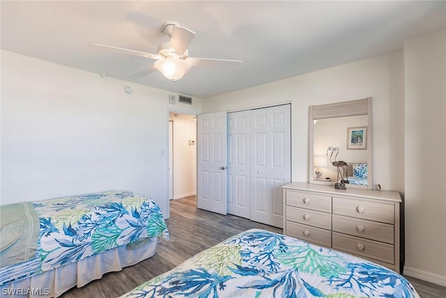 bedroom featuring visible vents, baseboards, wood finished floors, a closet, and a ceiling fan