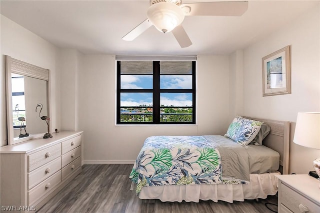 bedroom featuring baseboards, multiple windows, dark wood-type flooring, and ceiling fan