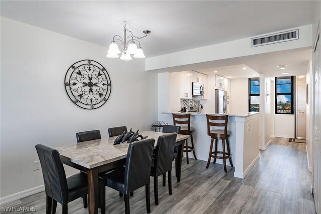 dining room featuring a notable chandelier and hardwood / wood-style flooring