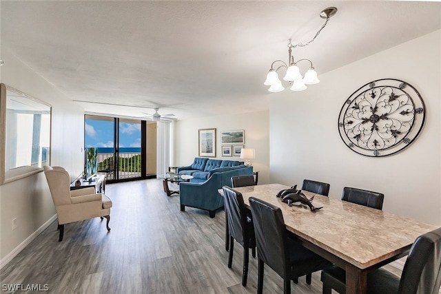 dining space featuring ceiling fan with notable chandelier and hardwood / wood-style flooring