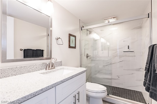 bathroom with toilet, vanity, and an enclosed shower