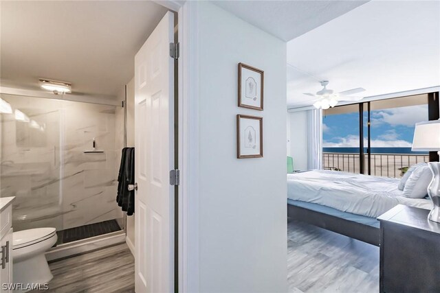 bedroom featuring access to exterior, ceiling fan, light hardwood / wood-style flooring, and floor to ceiling windows