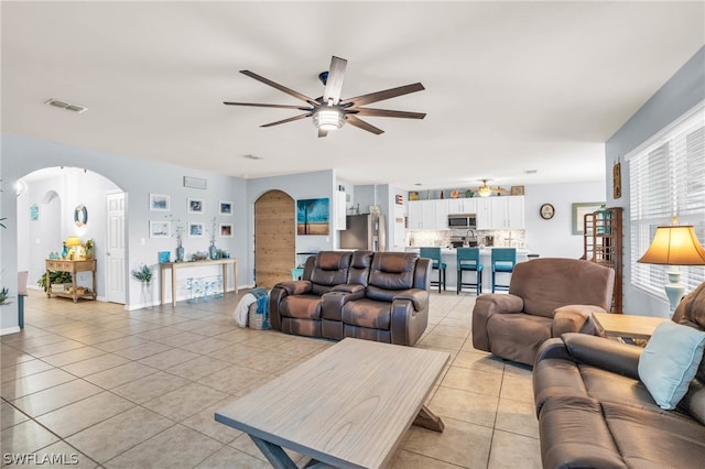 living room featuring light tile patterned floors and ceiling fan