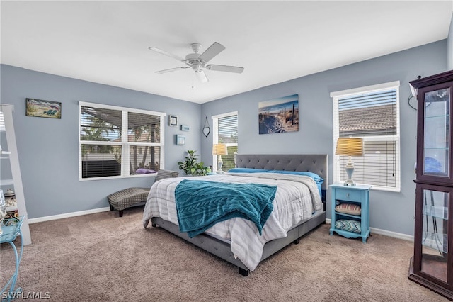 carpeted bedroom featuring multiple windows and ceiling fan