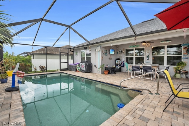 view of swimming pool featuring ceiling fan, a patio area, and a lanai