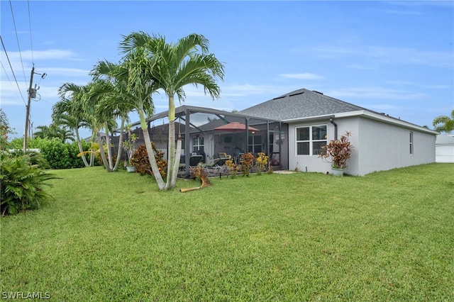 rear view of property featuring a lawn and a lanai