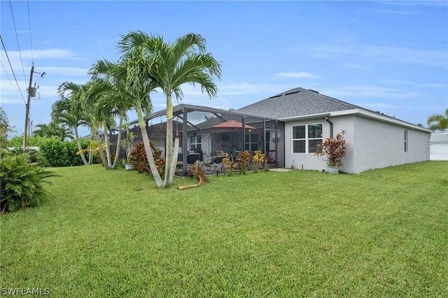 back of property with glass enclosure and a lawn