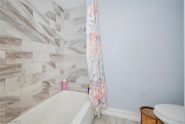 bathroom featuring shower / bath combo with shower curtain, toilet, and hardwood / wood-style flooring