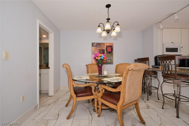 dining room featuring light tile patterned flooring, a notable chandelier, and rail lighting