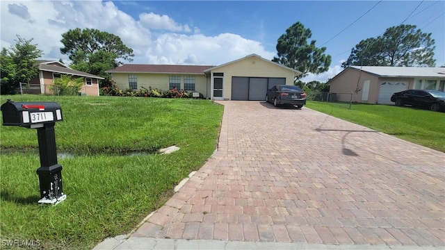 ranch-style house with fence, decorative driveway, a front lawn, and a garage