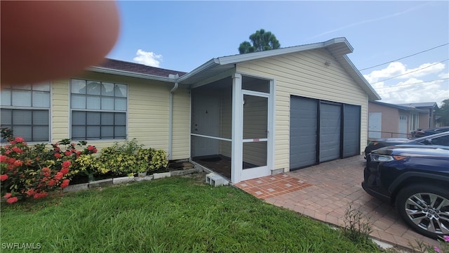 view of side of home with a sunroom and a garage