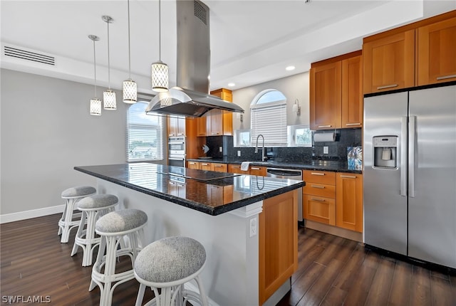 kitchen with a center island, appliances with stainless steel finishes, dark hardwood / wood-style floors, pendant lighting, and tasteful backsplash