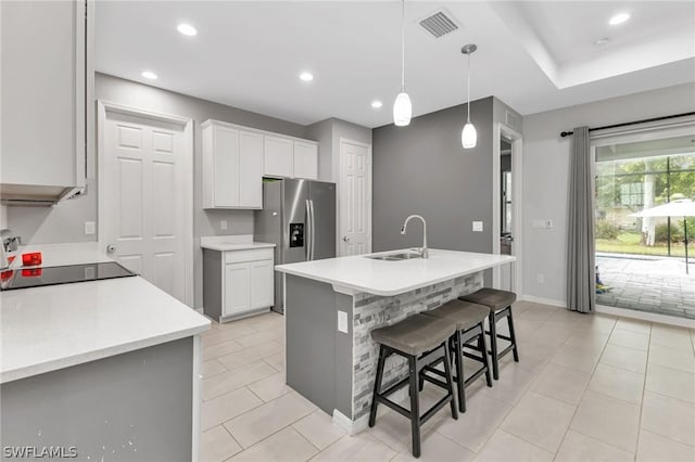 kitchen with recessed lighting, a breakfast bar area, a sink, and stainless steel fridge with ice dispenser