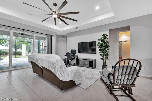 bedroom featuring baseboards, a tray ceiling, visible vents, and access to exterior