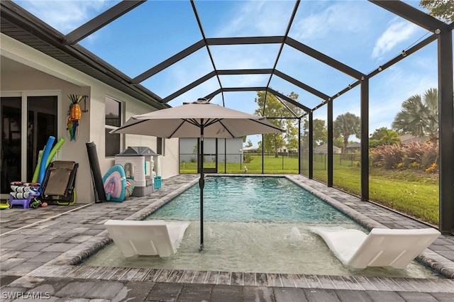 view of pool with a yard, a patio area, and glass enclosure