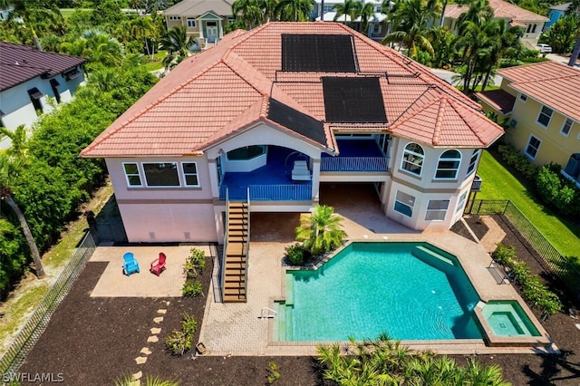 back of house with a garage and a fenced in pool